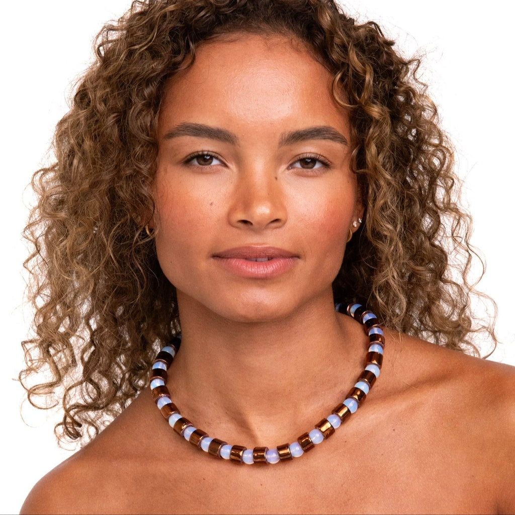 Woman wearing a beaded necklace on a white background