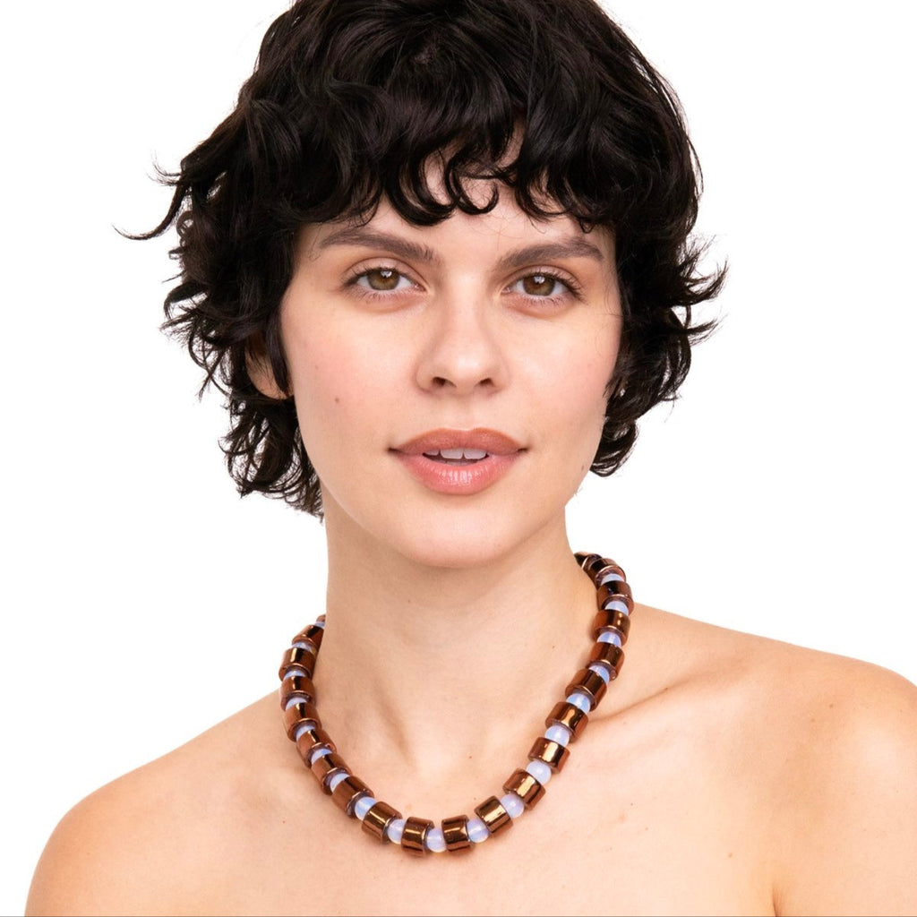 Woman wearing a beaded necklace on a white background